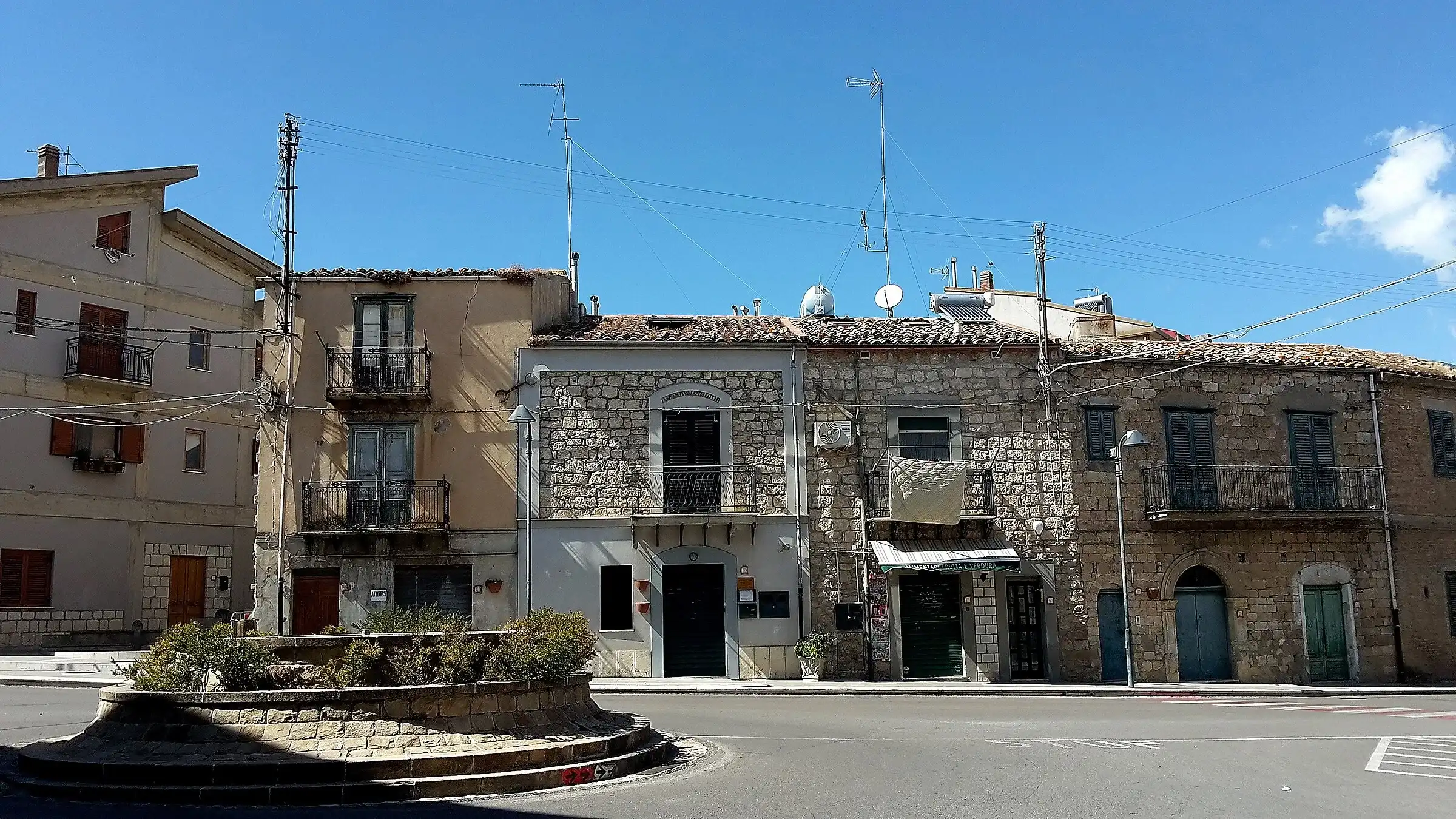 Una piazza di Castellana Sicula con le case in pietra e un’aiuola rotonda