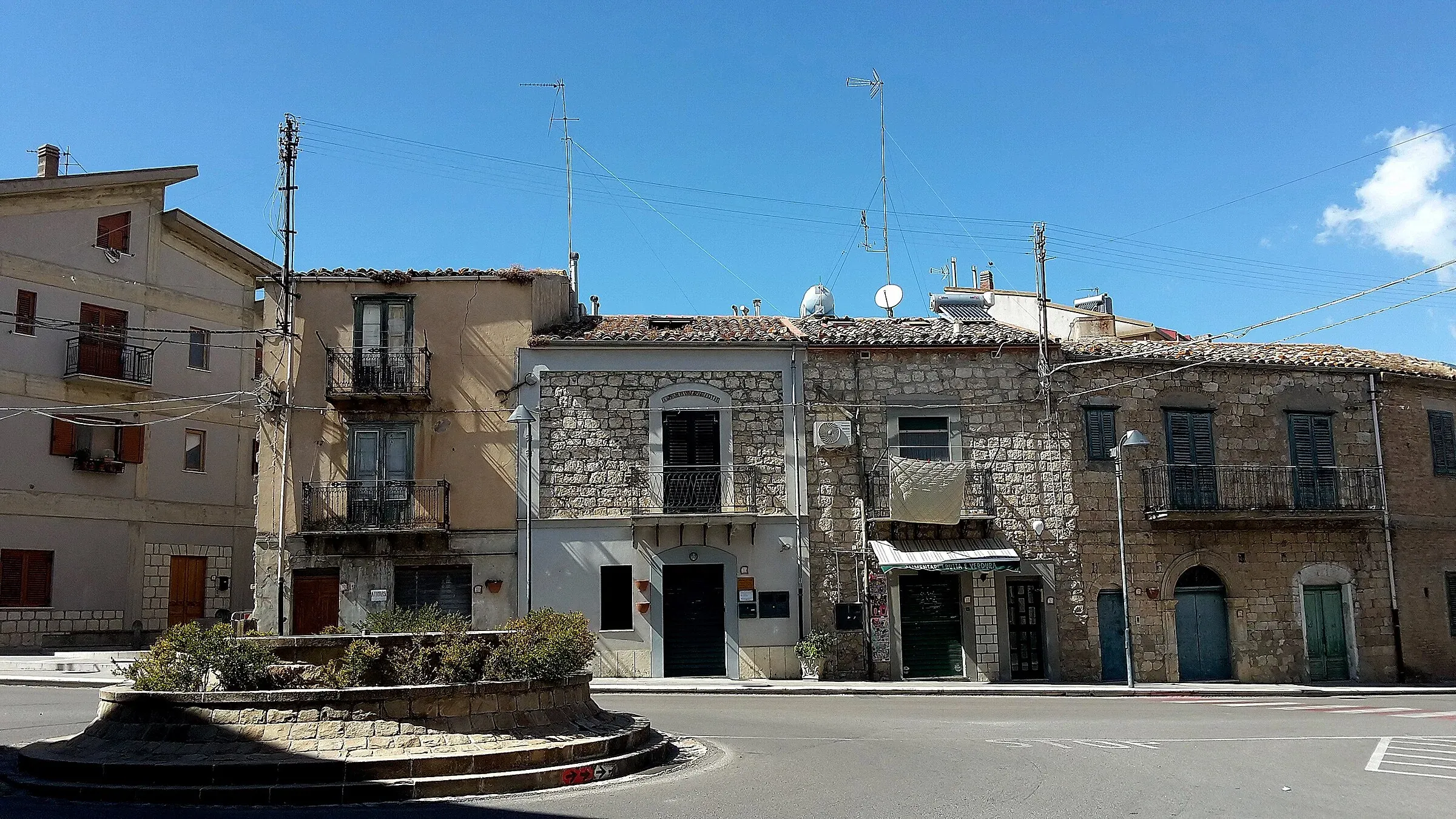 Una piazza di Castellana Sicula con le case in pietra e un’aiuola rotonda