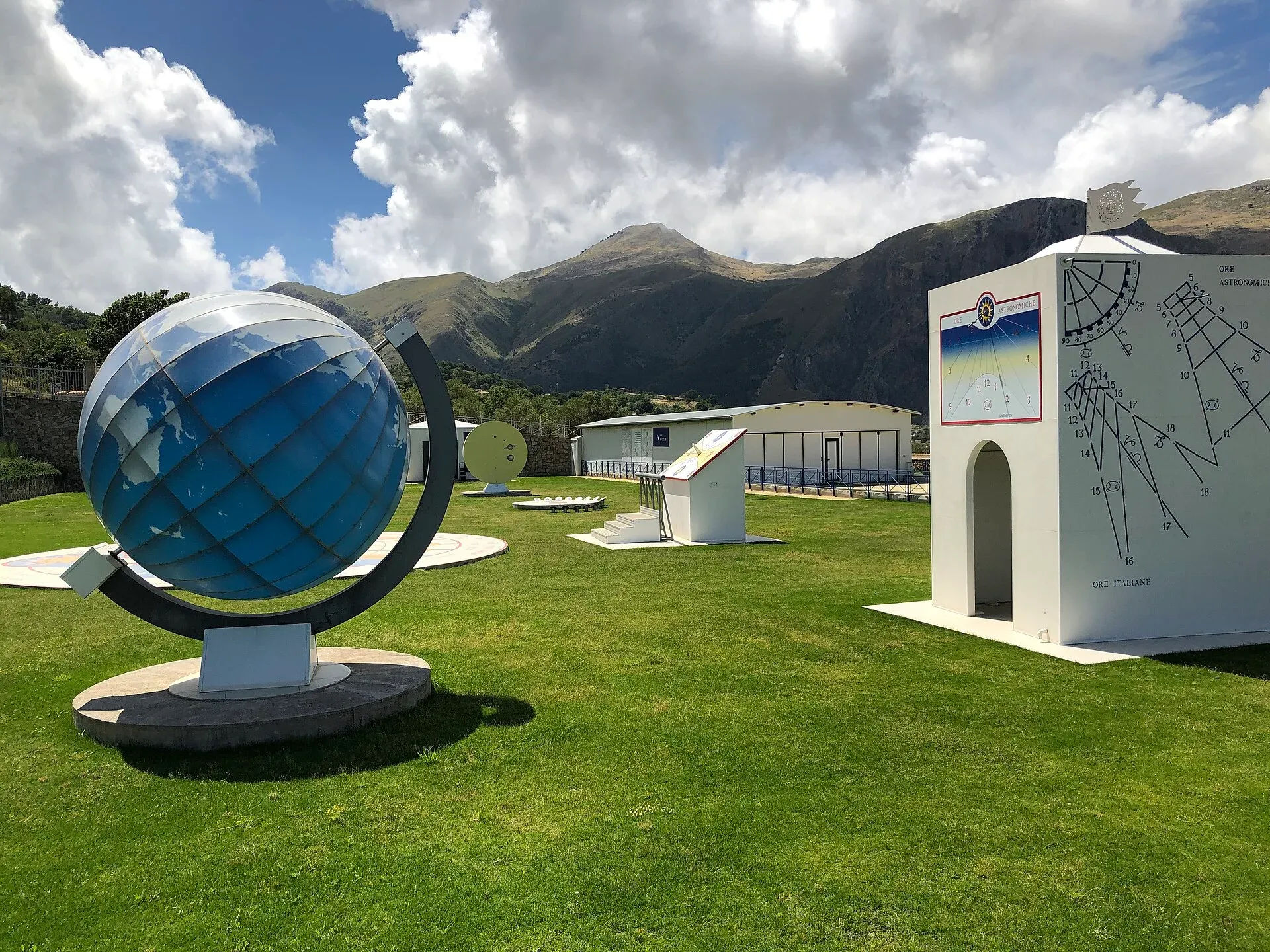 Il Parco dello Spazio e del Tempo del GAL Hassin a Isnello: il grande globo, le meridiane sul prato e i monti dietro