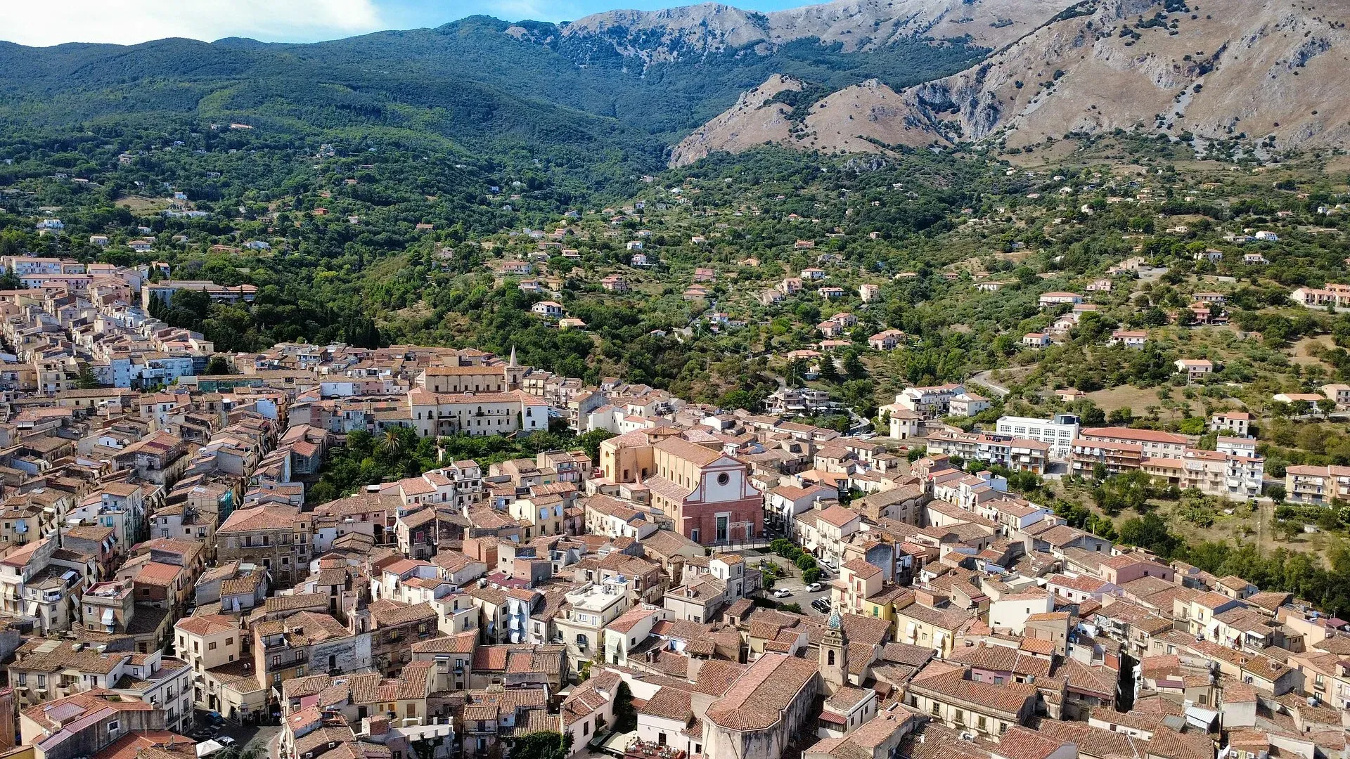 Castelbuono vista dall’alto, con i tetti del centro storico e i monti delle Madonie dietro