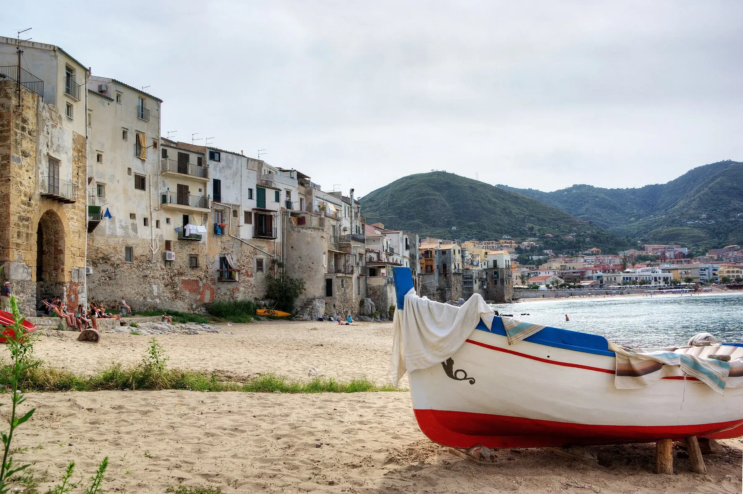Una barca tirata in secco sulla spiaggia della Vecchia Marina di Cefalù, davanti alle case sul mare
