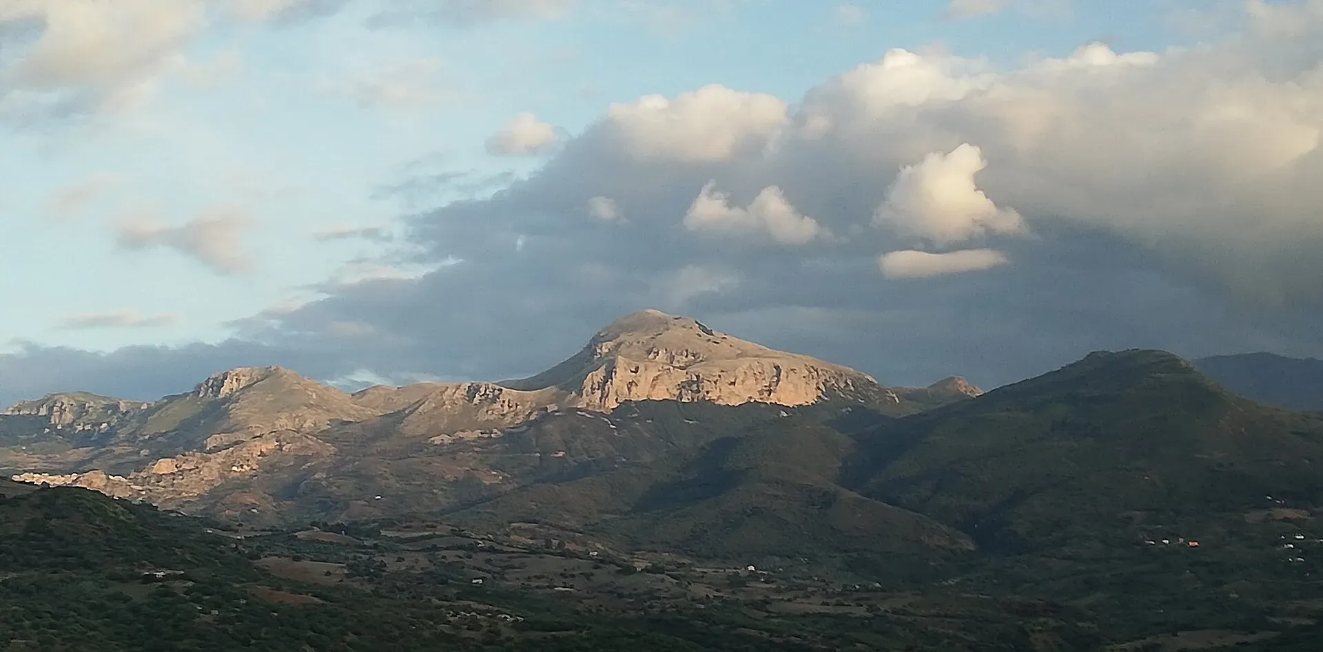 Il gruppo di Pizzo Dipilo nel sole basso del tardo pomeriggio, sotto grandi nuvole, dalla strada vicino a Collesano