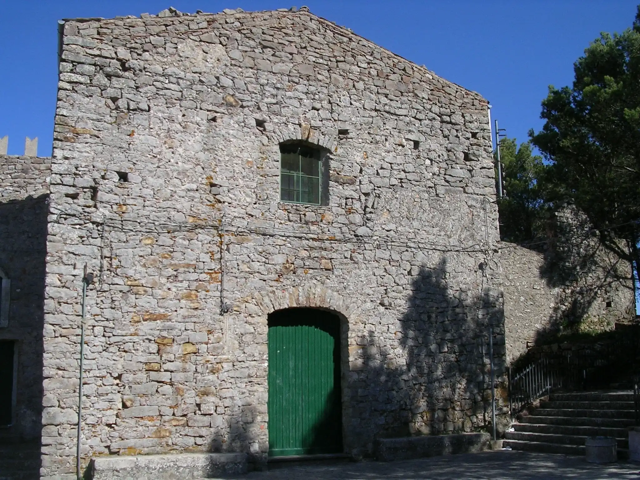 La chiesa di San Giacomo a Geraci Siculo, in pietra grigia con il portone verde, vicino al castello