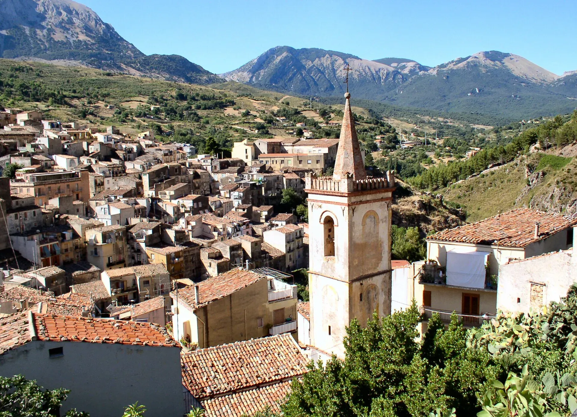 Il campanile di Isnello sopra le case, con le montagne delle Madonie sullo sfondo