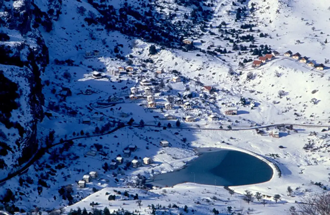 Piano Zucchi innevato visto dall’alto di Pizzo Carbonara, con il laghetto e le case sparse tra i boschi