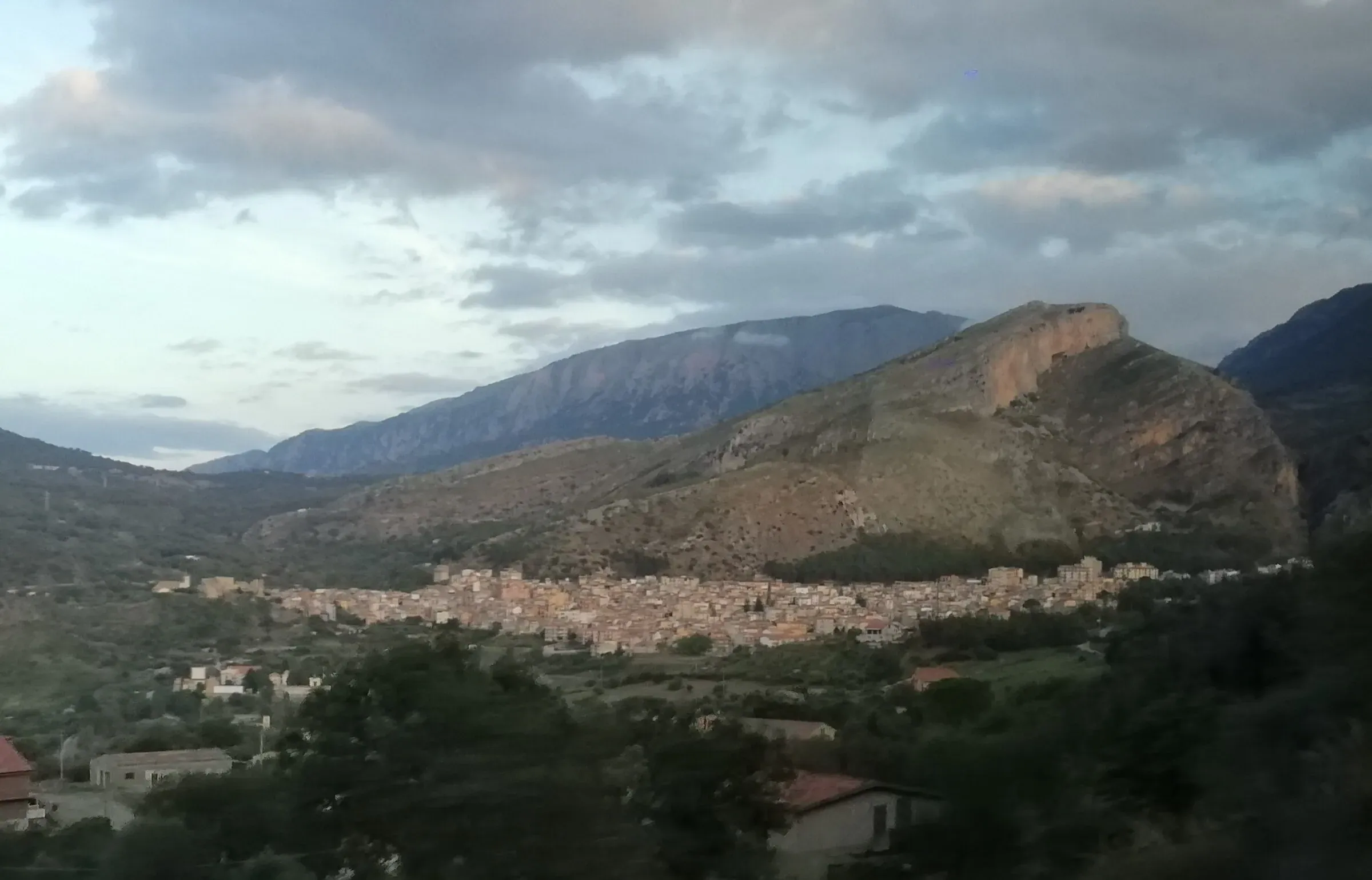 Collesano ai piedi della montagna, vista dalla strada provinciale all’imbrunire