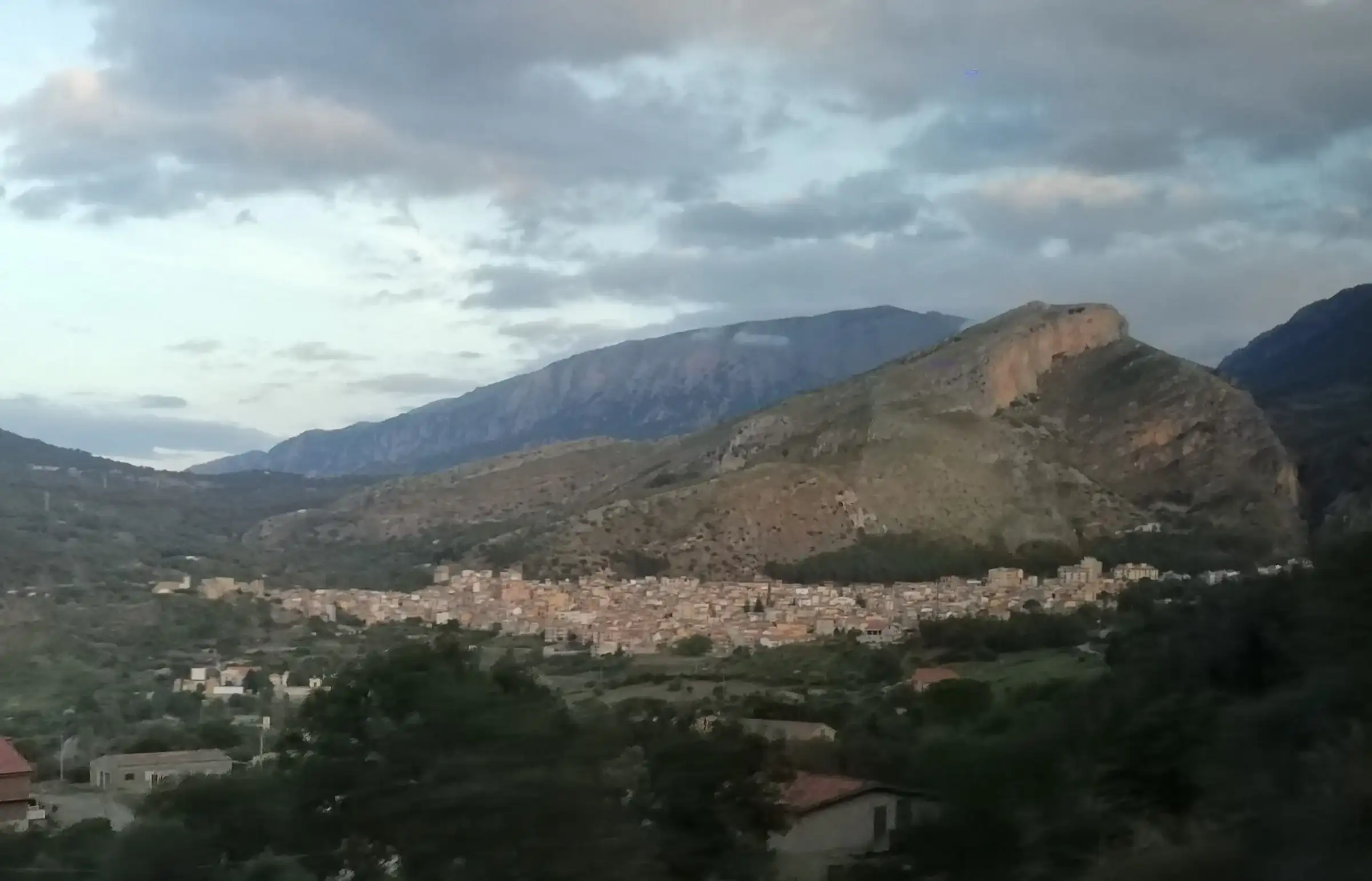 Collesano ai piedi della montagna, vista dalla strada provinciale all’imbrunire