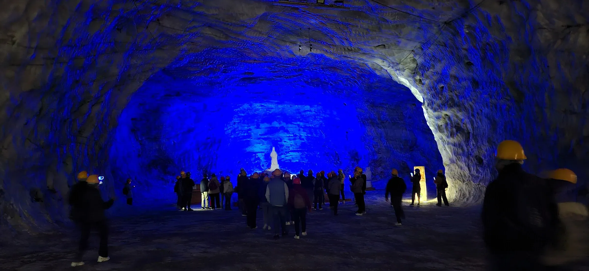 Una galleria della miniera di salgemma di Petralia Soprana illuminata di blu, con un gruppo di visitatori