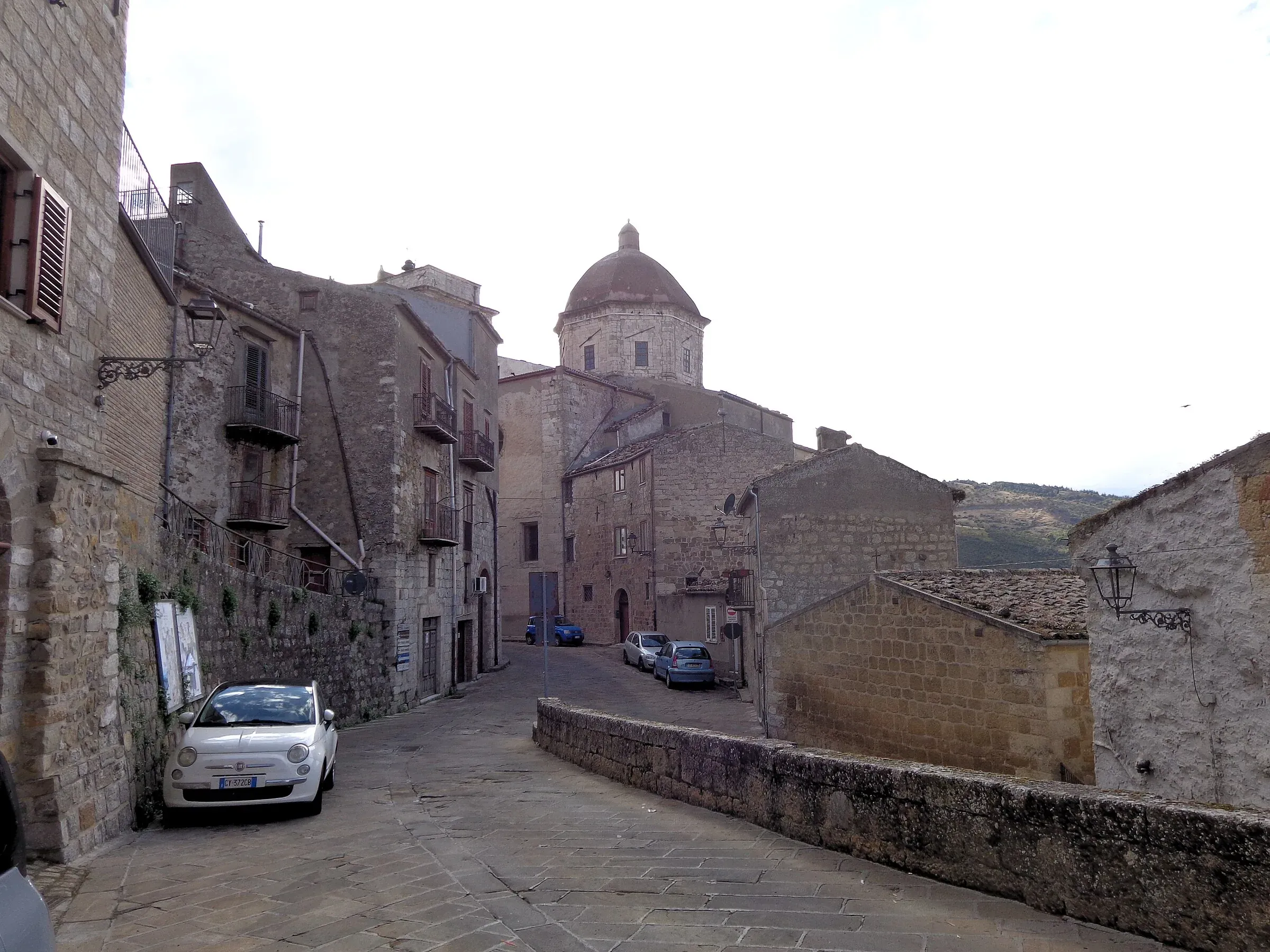 La chiesa Madre di Petralia Sottana con la cupola, in fondo a una via in pietra del centro