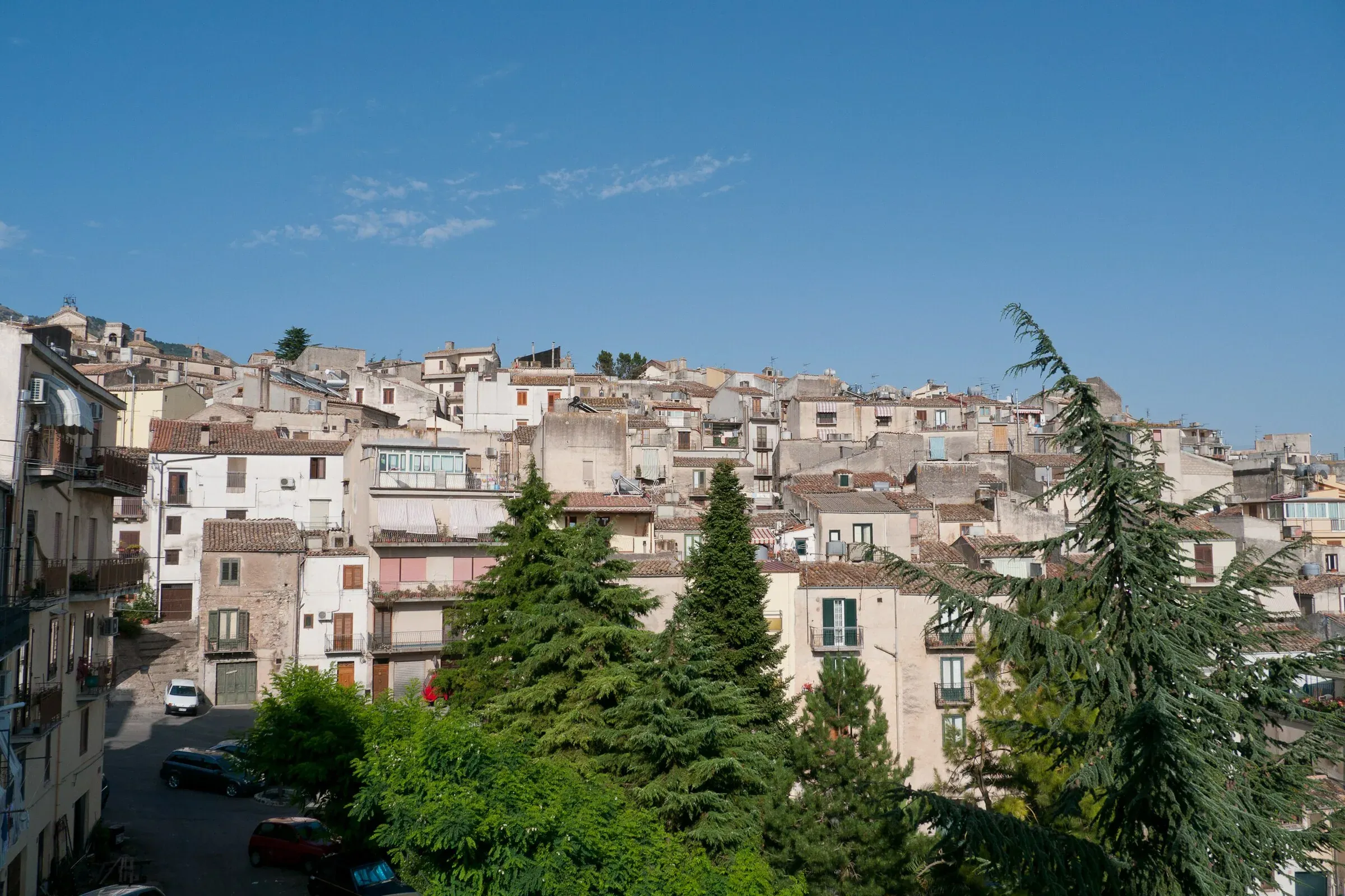Le case di Polizzi Generosa sul colle, tra gli abeti, sotto il cielo sereno