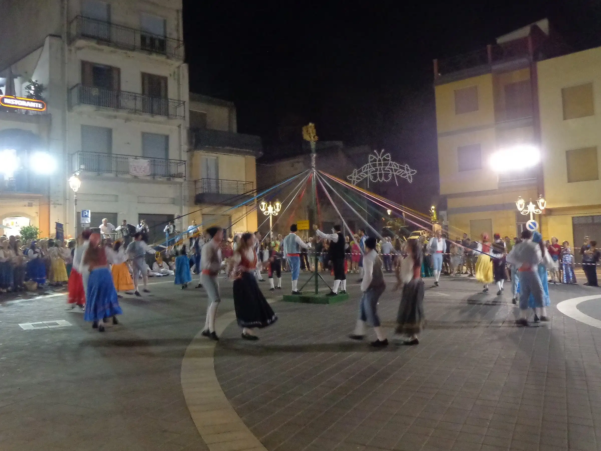 Il gruppo folk di Petralia Sottana balla la Cordella intorno al palo con i nastri colorati, a Rodì Milici nel 2024