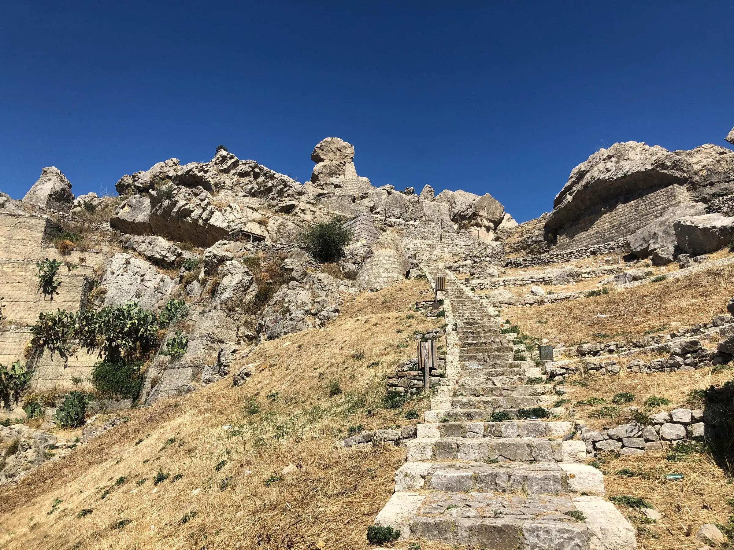 Scalinata di pietra tra le rocce chiare della rupe di Terravecchia, sopra Caltavuturo, dove stava il paese medievale