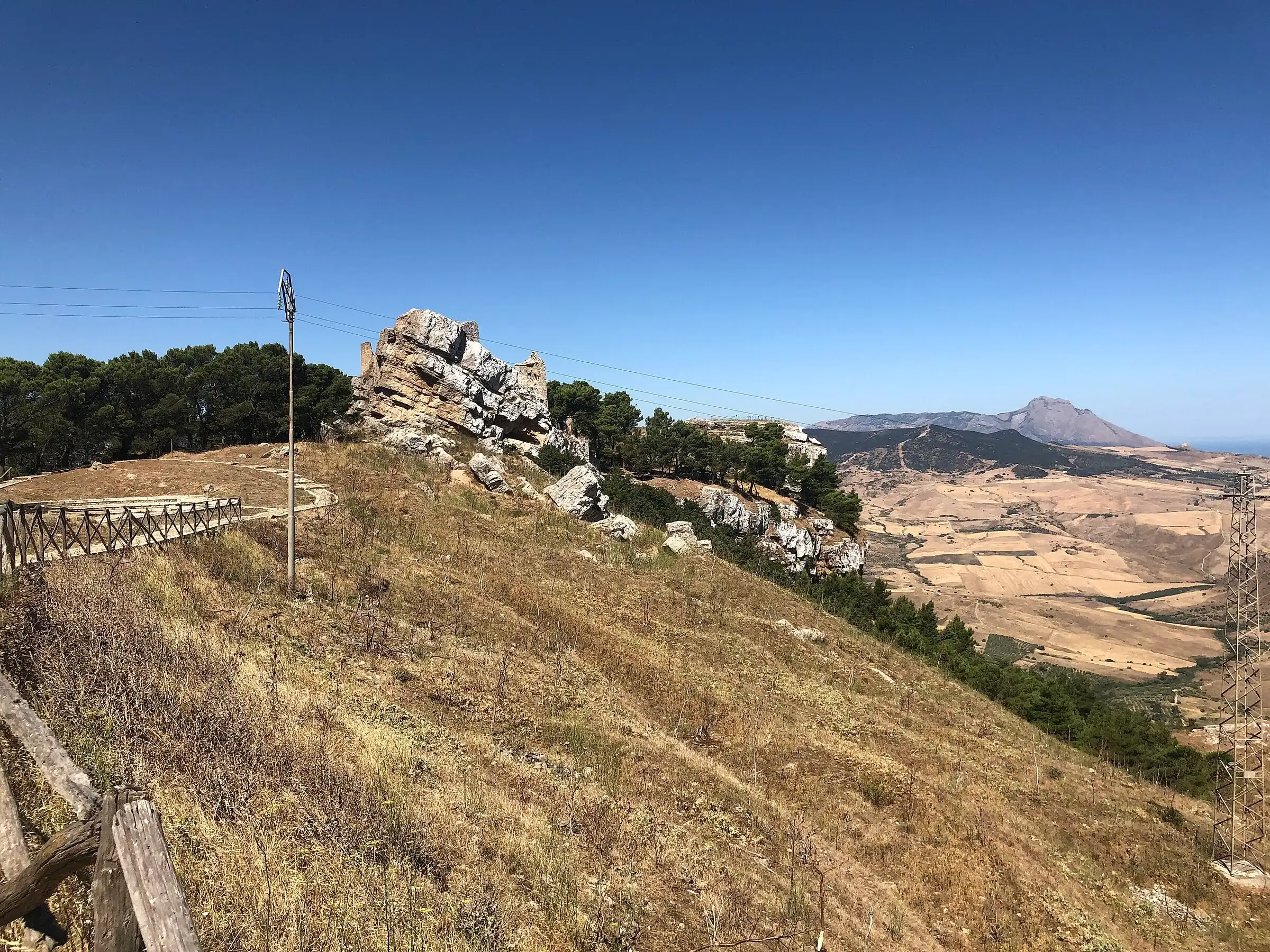 Un sentiero sul crinale di Terravecchia sopra Caltavuturo, tra prati secchi e rocce, con le colline all’orizzonte